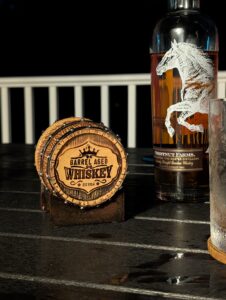 Whiskey Barrel Coaster sitting on deck table next to Chestnut Farms Bourbon